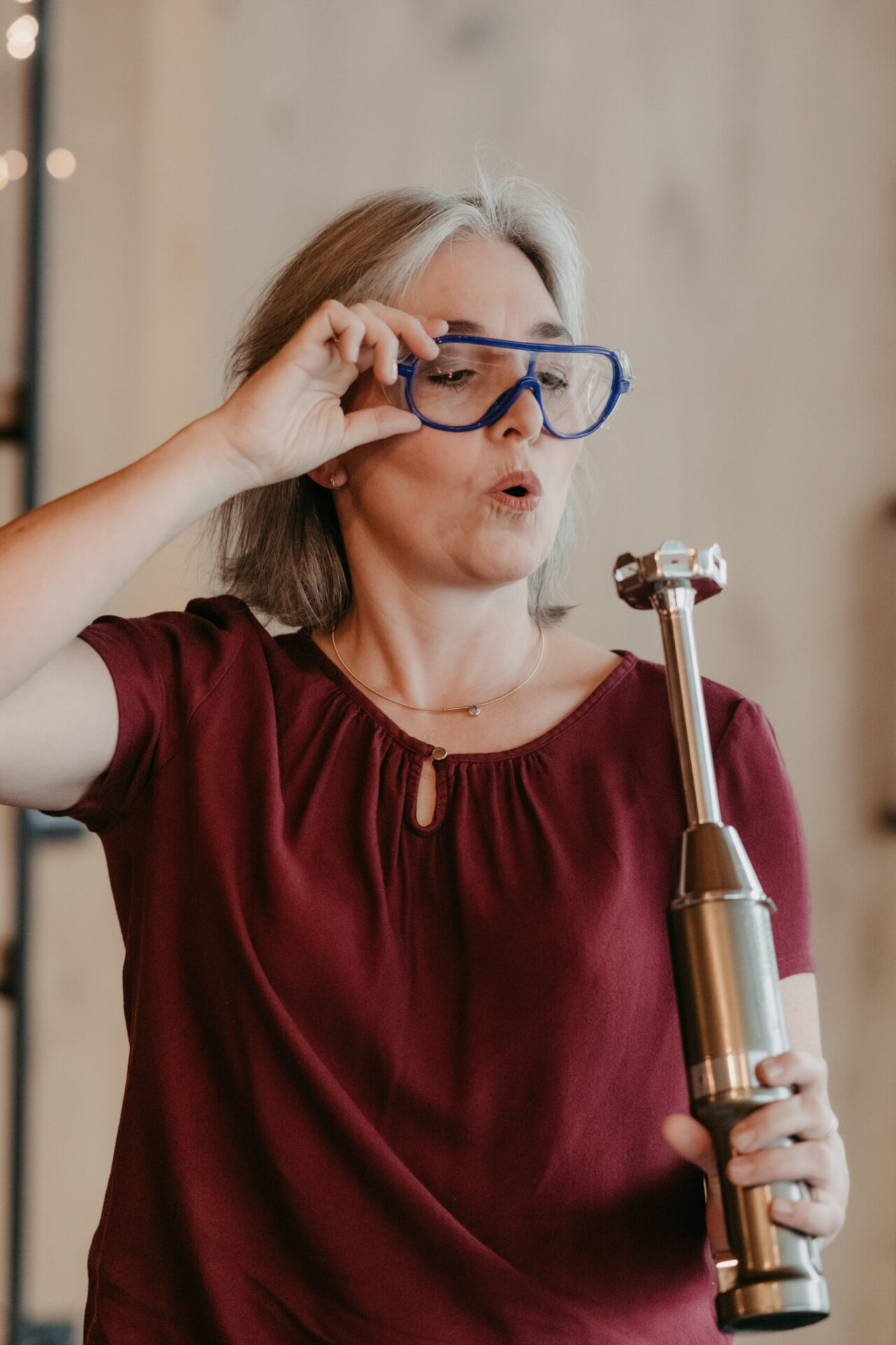 Dr. Jessica Maas hebt eine Schutzbrille an und hält einen Pürierstab, beim Seifensieden.