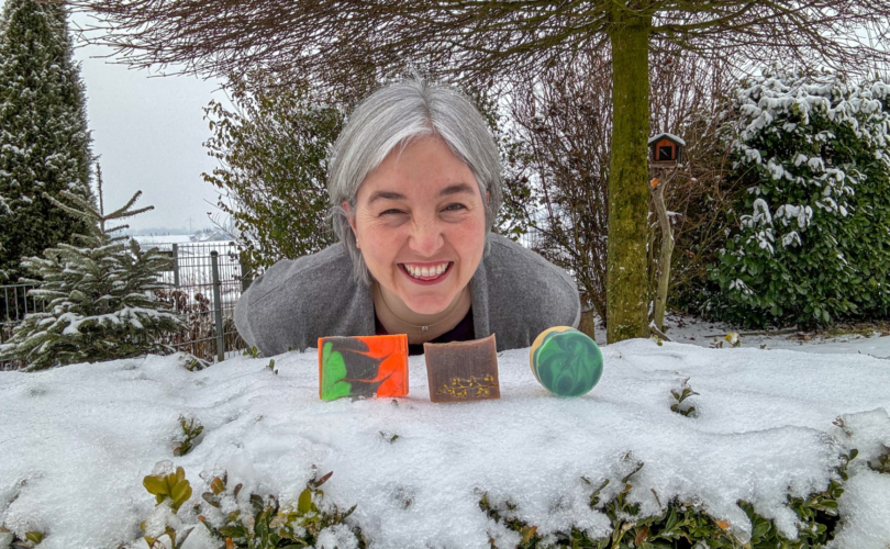 Jessica vor Seifen, die auf schneebedecktem Buchs liegen