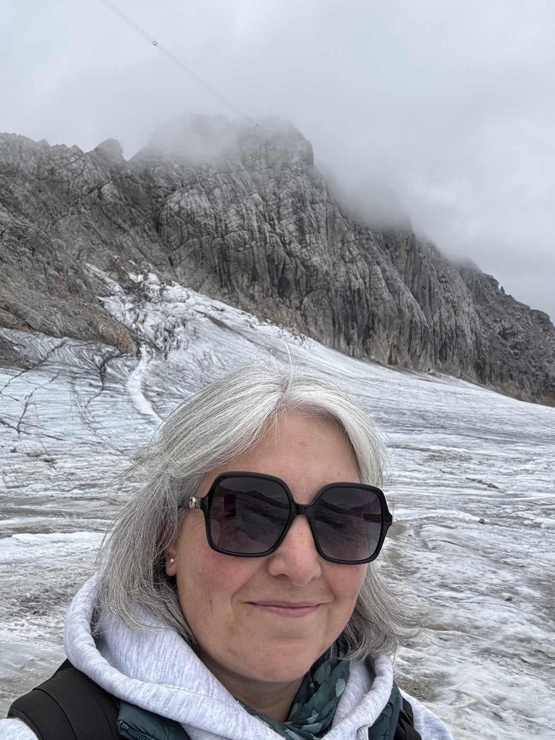 Dr. Jessica Maas mit Sonnenbrille vor dem Dachstein-Gletscher auf über 2700 Metern Höhe